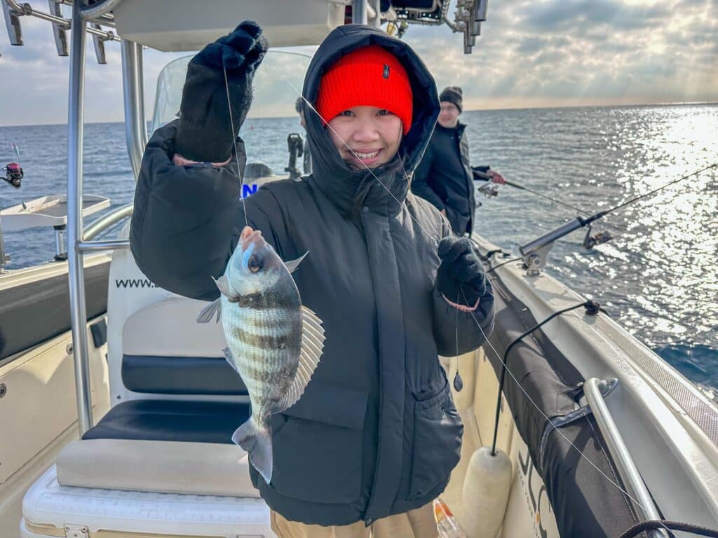 Clienta con un pez pescado en la excursión de pesca.