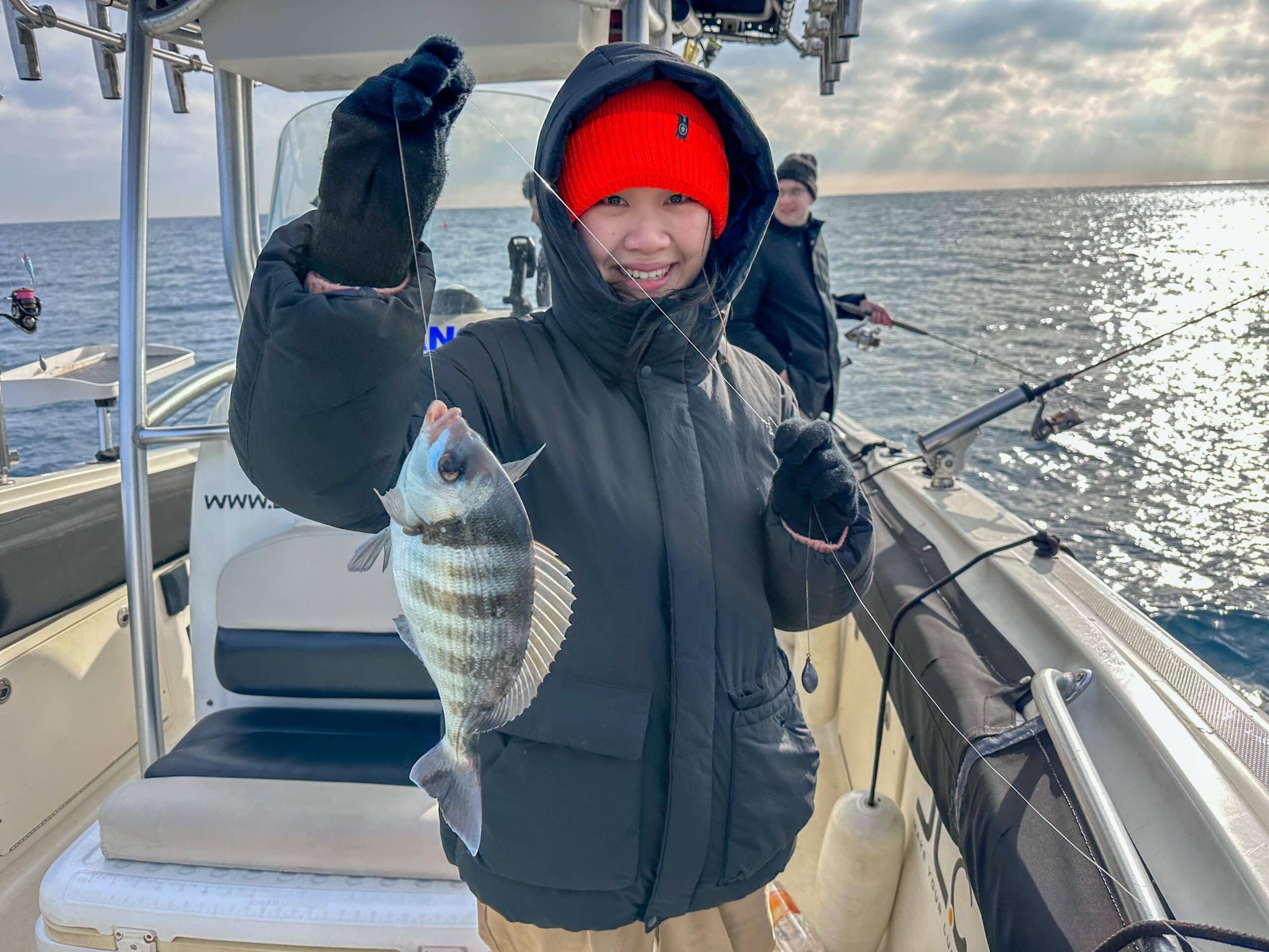 Clienta con un pez pescado en la excursión de pesca.
